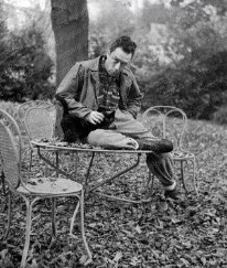 F819 Albert Camus assis avec son chat à Bougival, dans la propriété de Guy Shoeller pendant la pièce de théâtre Caligula, novembre 1945.