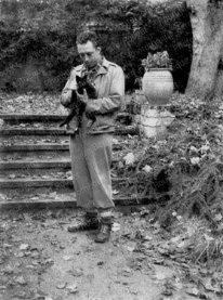 F821 Albert Camus avec son chat à Bougival, dans la propriété de Guy Shoeller, pendant la pièce de théâtre Caligula, novembre 1945.